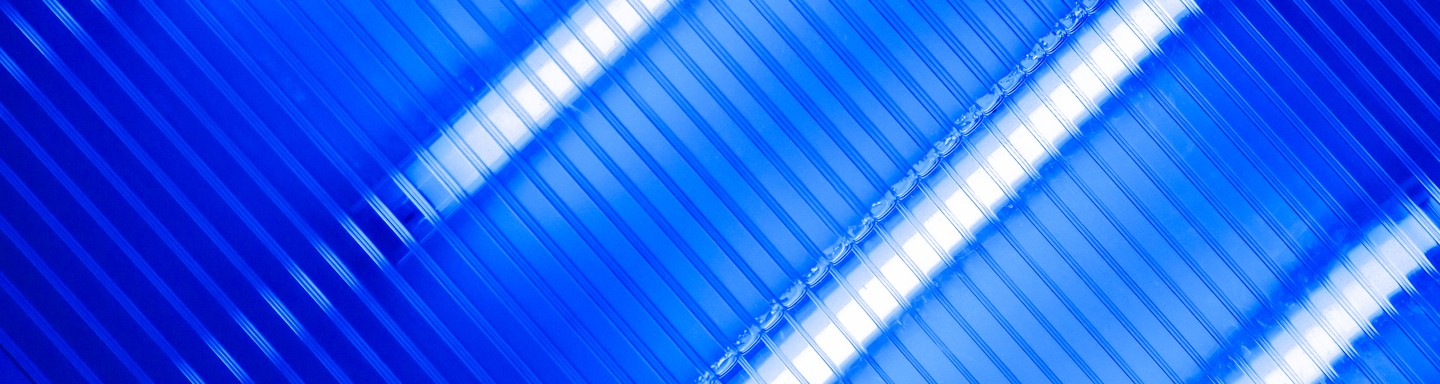 L'image présente un gros plan de lignes bleues diagonales avec des reflets blancs éclatants traversant le cadre.